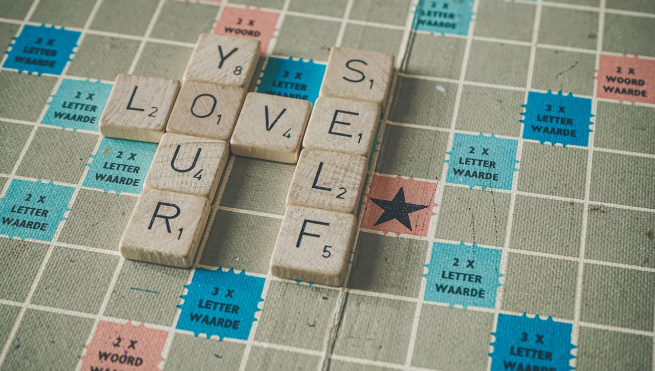 Scrabble tiles on a board spelling out the inspiring message 'Love Yourself.'